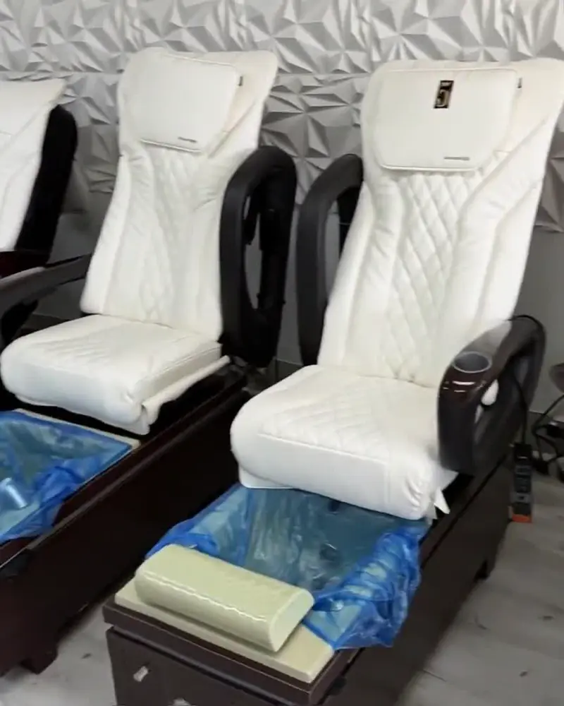 Row of white pedicure chairs at Creative Nails